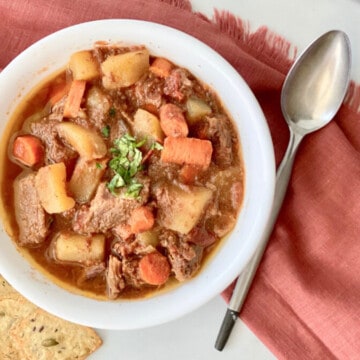 Slow Cooker Hungarian Goulash recipe card bowl crackers spoon and red napkin