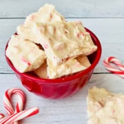 2-Ingredient Peppermint Bark red bowl filled with bark plus candy canes on the side