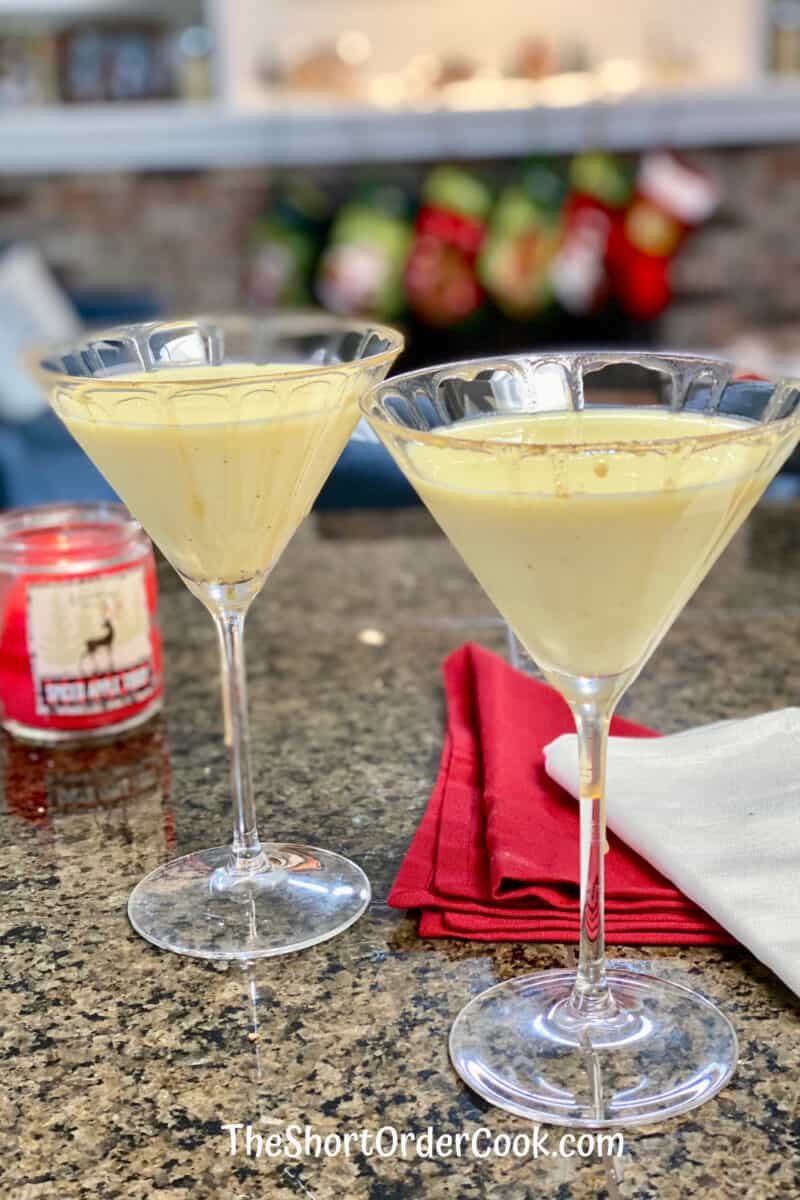 Eggnog Vodka Martini 2 glasses ready to drink with stockings and fireplace in the background