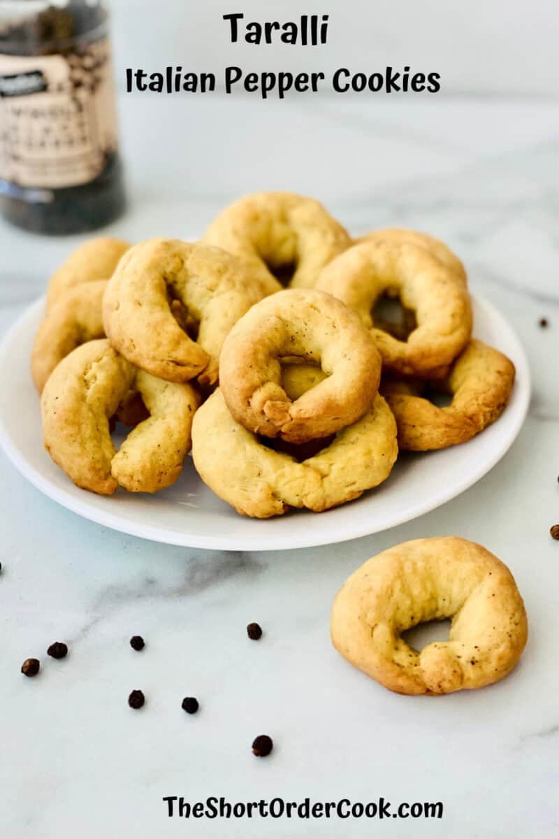 Taralli - Italian Pepper Cookies PN1 plated with peppercorns on the counter and a pepper shaker