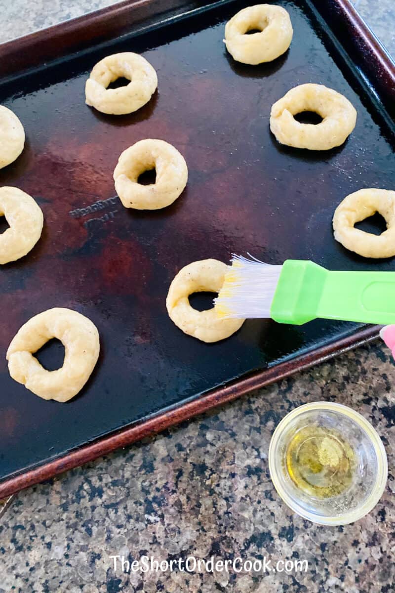 Taralli - Italian Pepper Cookies brush unbaked circles with olive oil on baking sheet