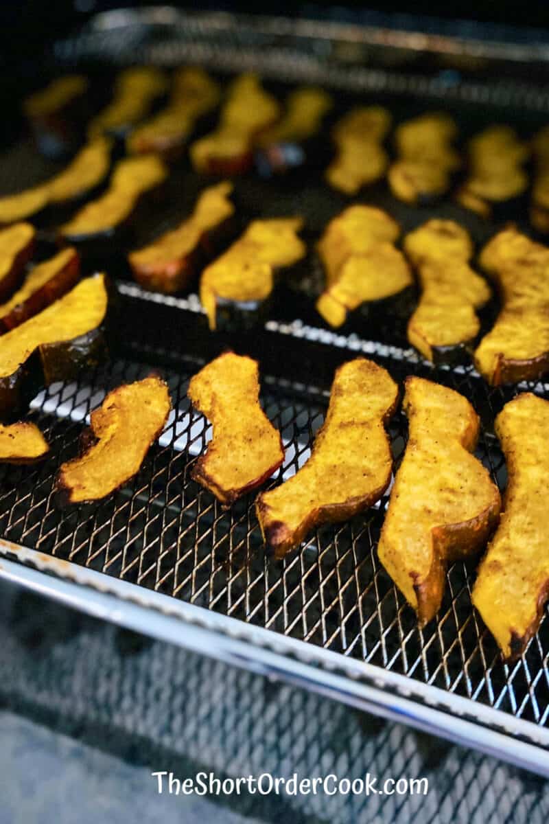 Air Fryer Curried Acorn Squash Slices cooked and ready on the tray in the air fryer