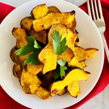 Air Fryer Curried Acorn Squash Slices with parsley recipe card plated with fork and red napkin