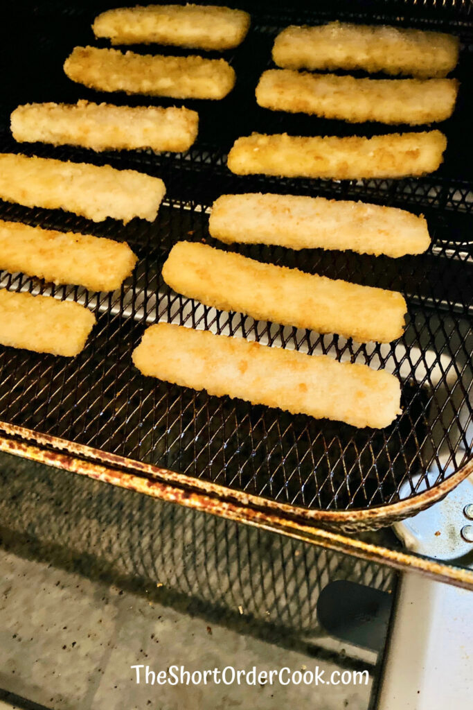 frozen fish sticks on the air fryer tray ready to cook