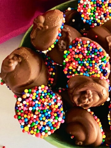 Chocolate Nonpareils Candy featured overhead of a bowl filled and a hot pink napkin