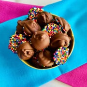 Chocolate Nonpareils Candy recipe card overhead of bowl filled with candy and blue and pink napkins