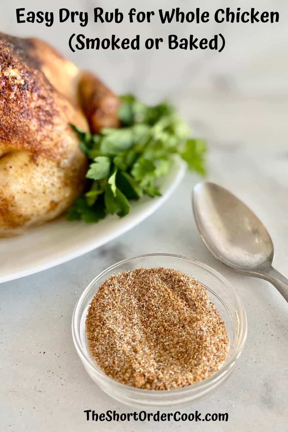 bowl of dry rub next to a baked chicken on a platter with fresh parsley