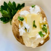 Toaster Oven Baked Potato topped recipe card with sour cream butter and fresh parsley