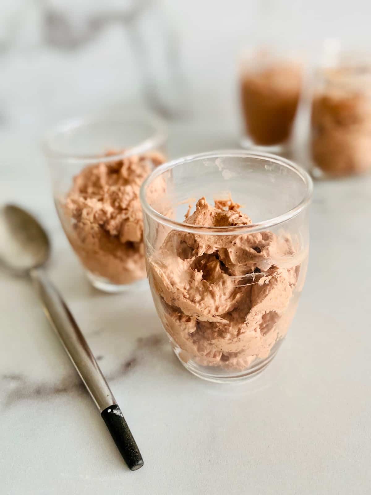 Easy Low-Carb Chocolate Mousse piled into serving glasses with a spoon