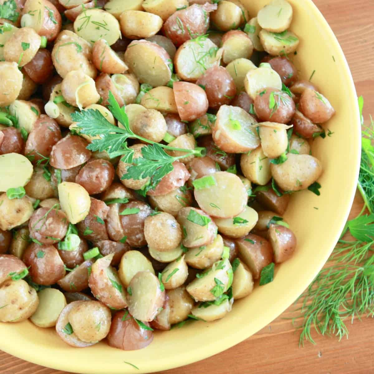 bowl with french potato salad topped with fresh herbs