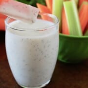 homemade keto ranch dressing in a glass cup with celery and carrots to dip
