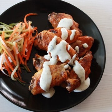 plated buffalo wings topped with ranch dressing