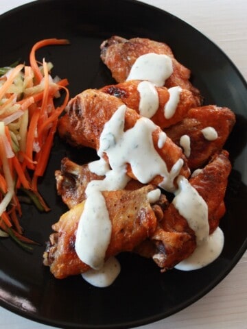 plated buffalo wings topped with ranch dressing