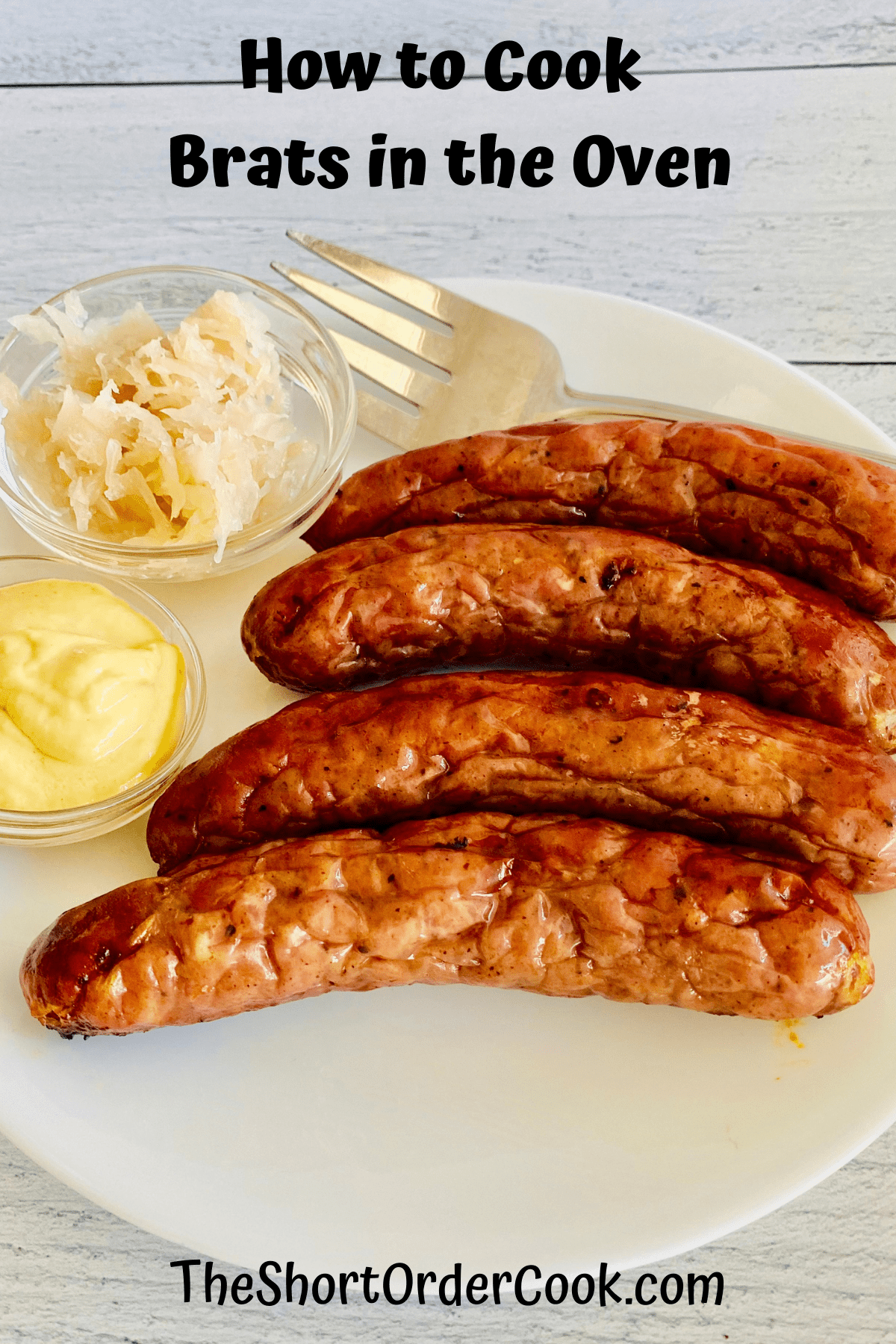 4 plated brown bratwurst sausages with mustard and sauerkraut