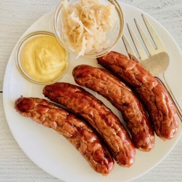 oven cooked plated with serving fork and small bowls of spicy mustard and kraut