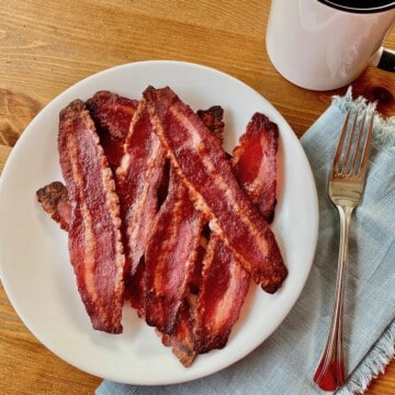 plate of cooked turkey bacon with a mug and fork on the table