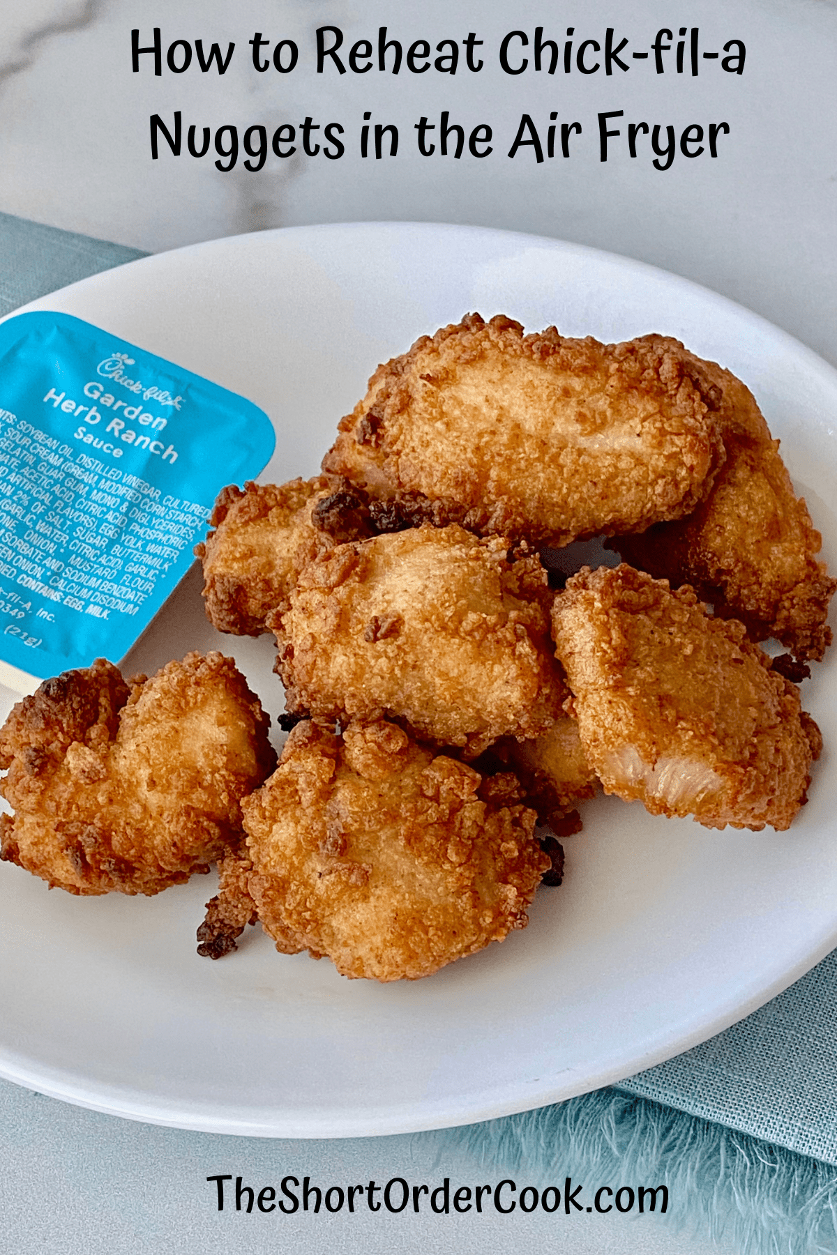 reheated nuggets on a plate with a packet of chick fil a ranch dip
