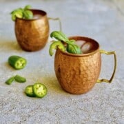 spicy jalapeno moscow mule with basil garnish in copper mugs