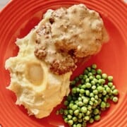 plated sailsbury steak with peas and mashed potatoes and gravy