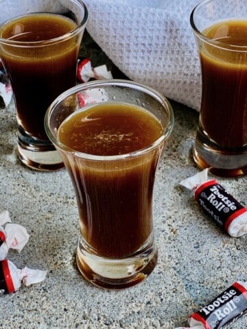 3 tootsie roll shots ready to drink with tootsie roll candies around