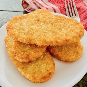 4 air fried hash brown patties on a white plate