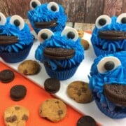 chocolate cupcakes with blue frosting candy eyeballs and oreo cookie mouths