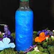 a tall glass filled with shimmery blue liquid
