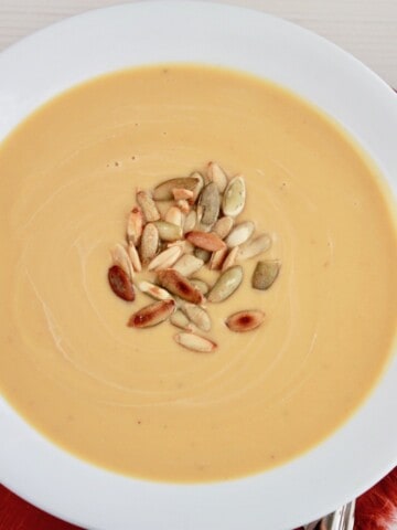 bowl of butternut squash soup topped with toasted pumpkin seeds
