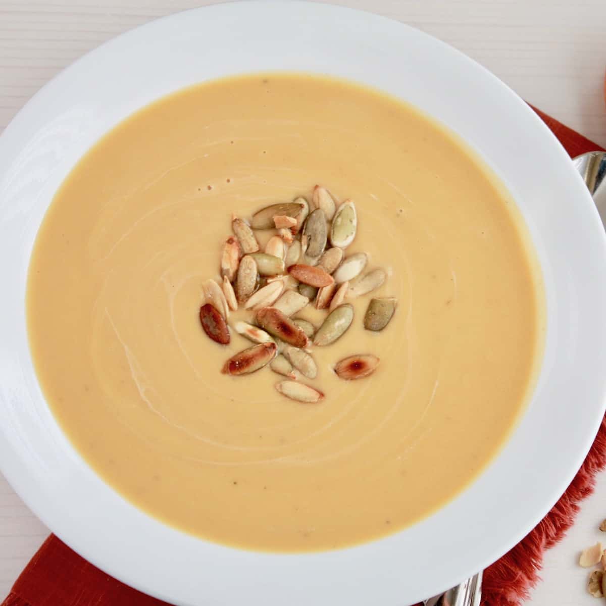 bowl of butternut squash soup topped with toasted pumpkin seeds
