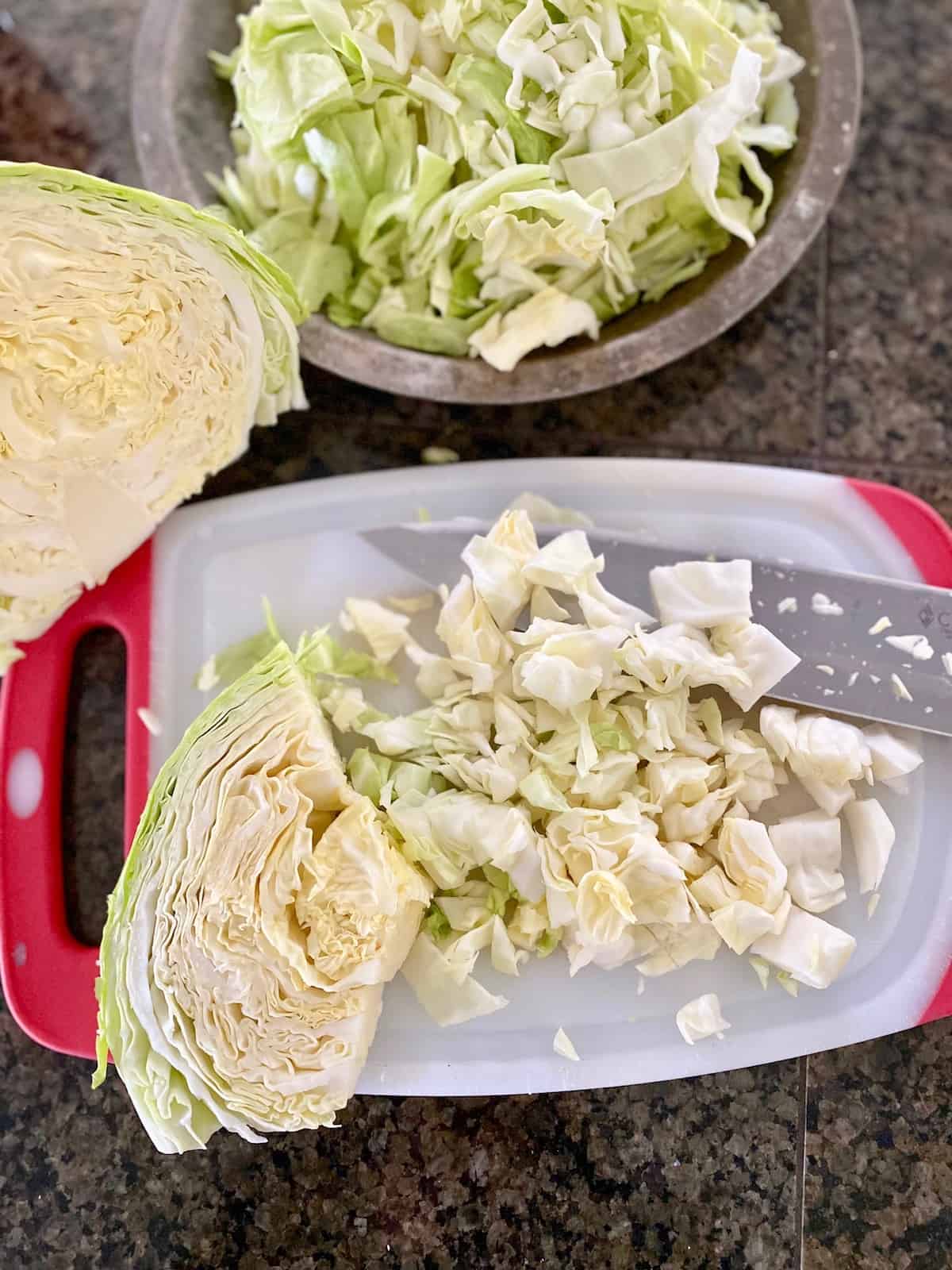 cabbage being chopped on a cutting board
