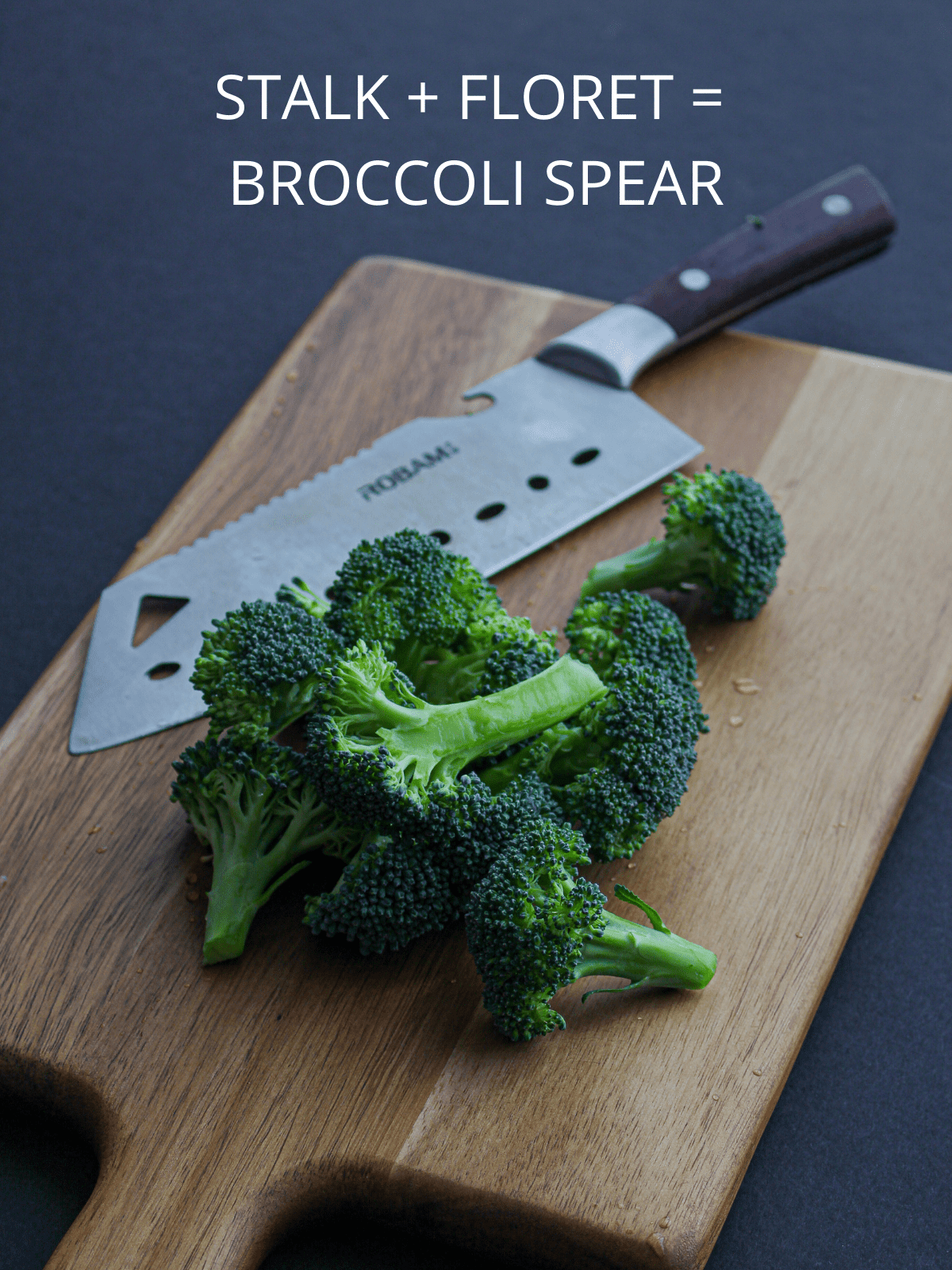 A cutting board with spears of broccoli and a knife.