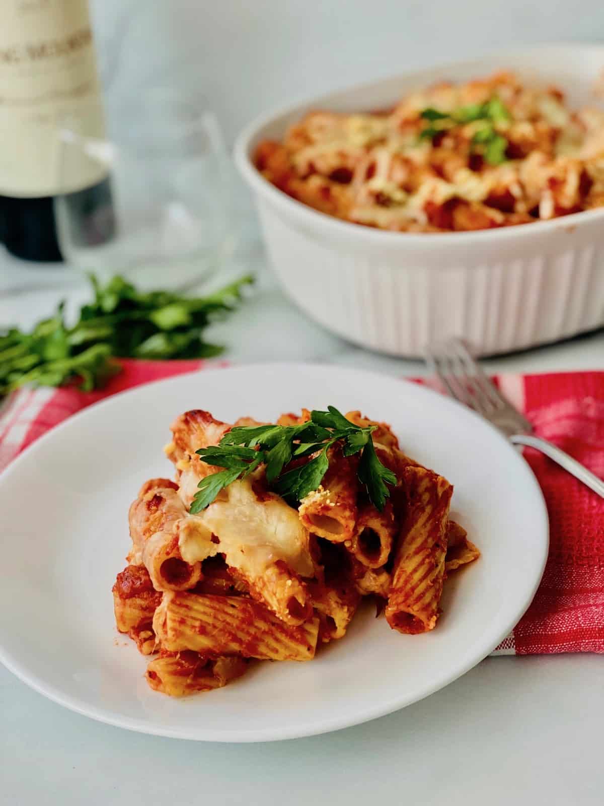 Plated rigatoni a al forno casserole dish plus wine on the table