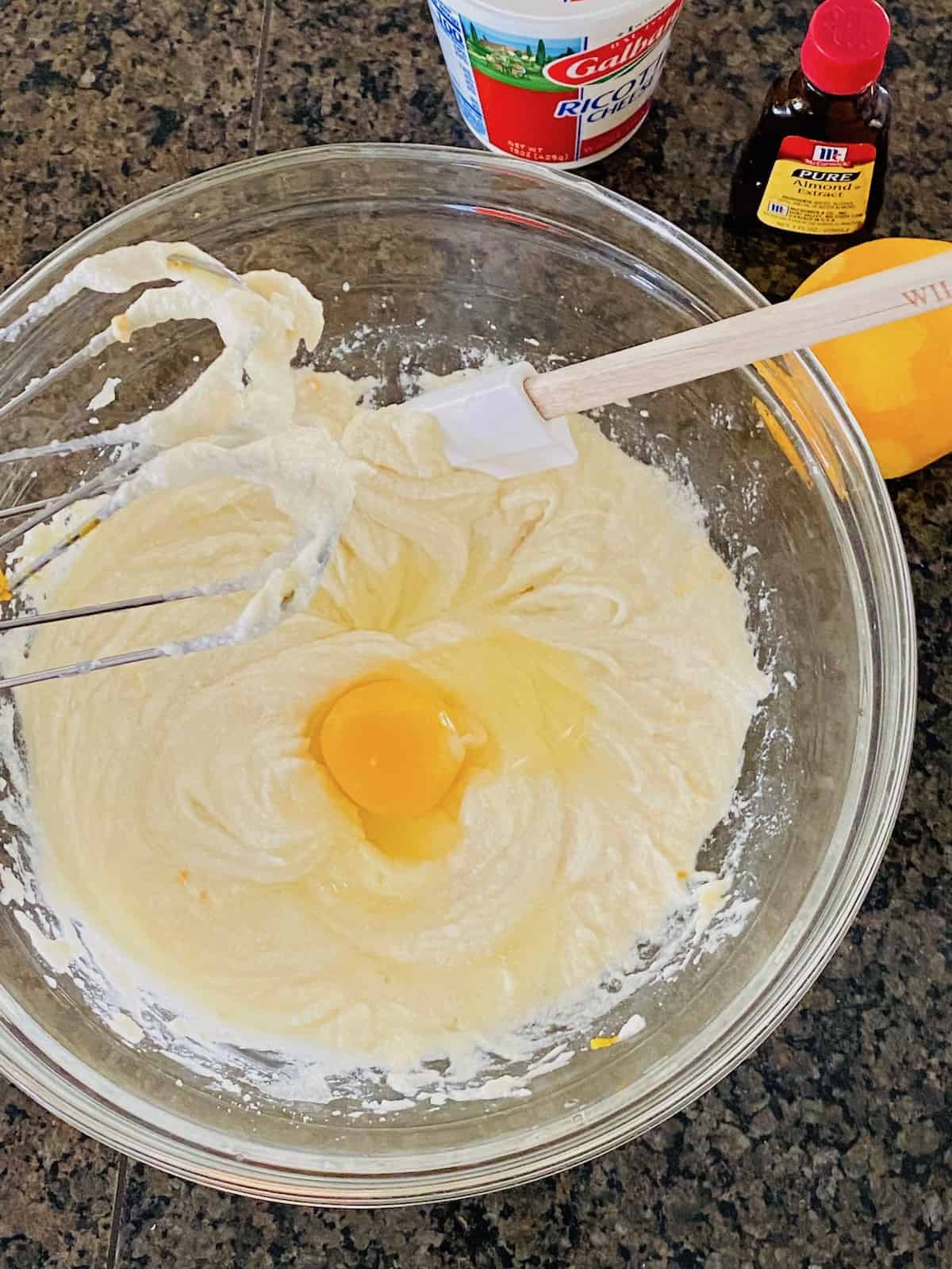 adding the egg to the other ingredients in the bowl.