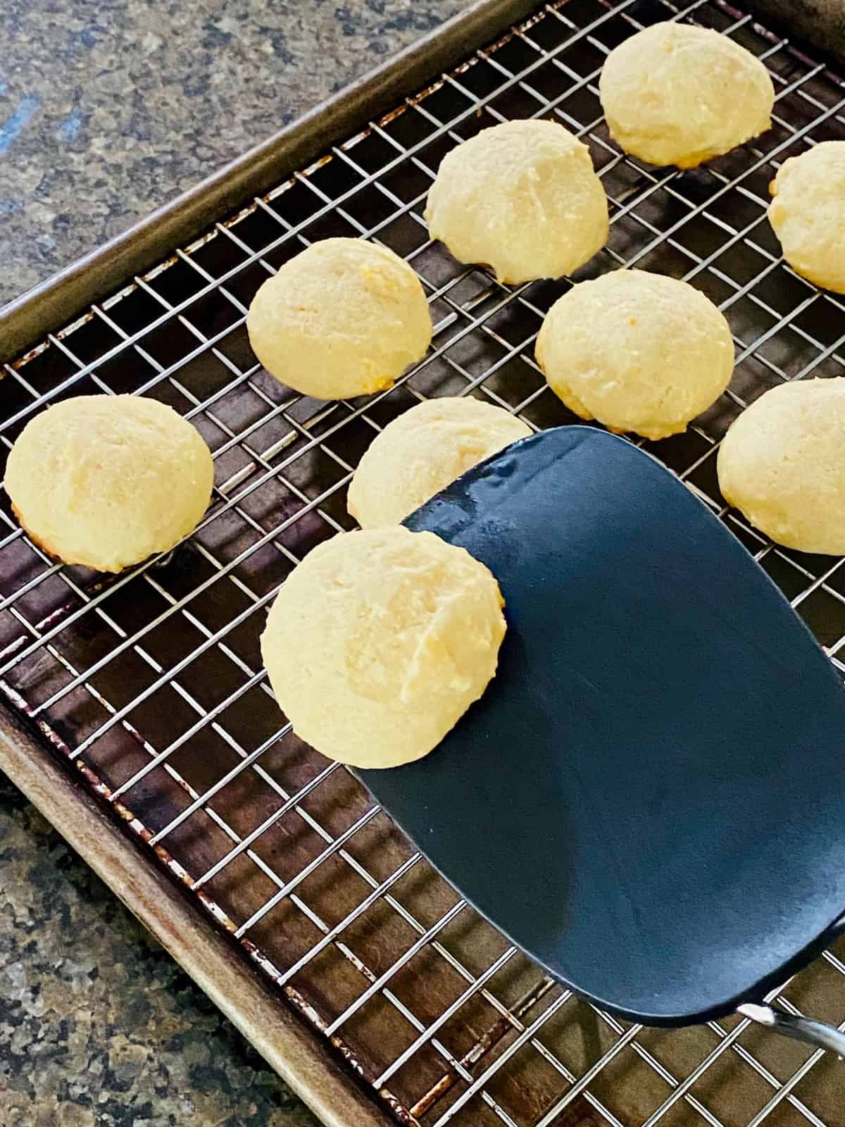 using a spatula to move hot cookies to a cooling rack.