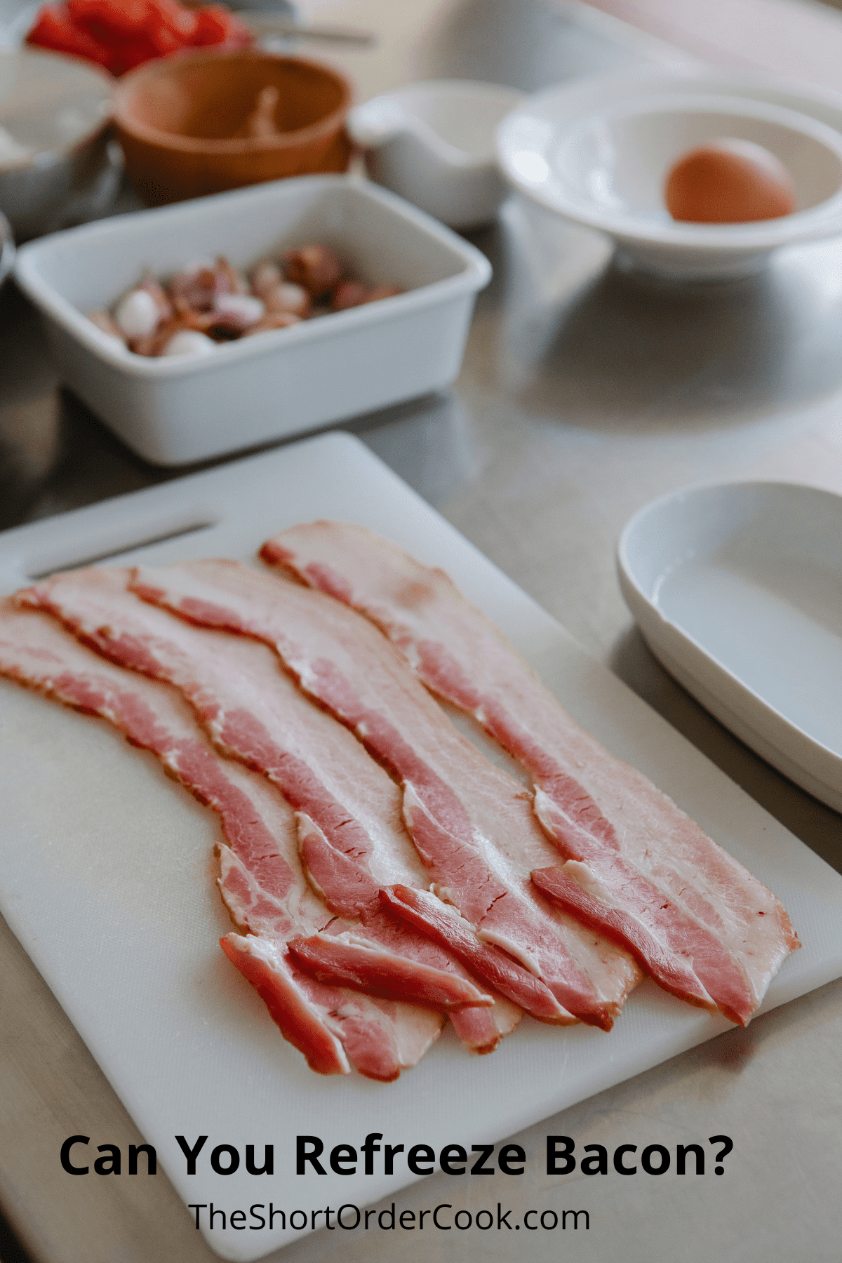 Uncooked bacon slices on a white cutting board.