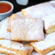 A plate of beignets covered in powdered sugar.