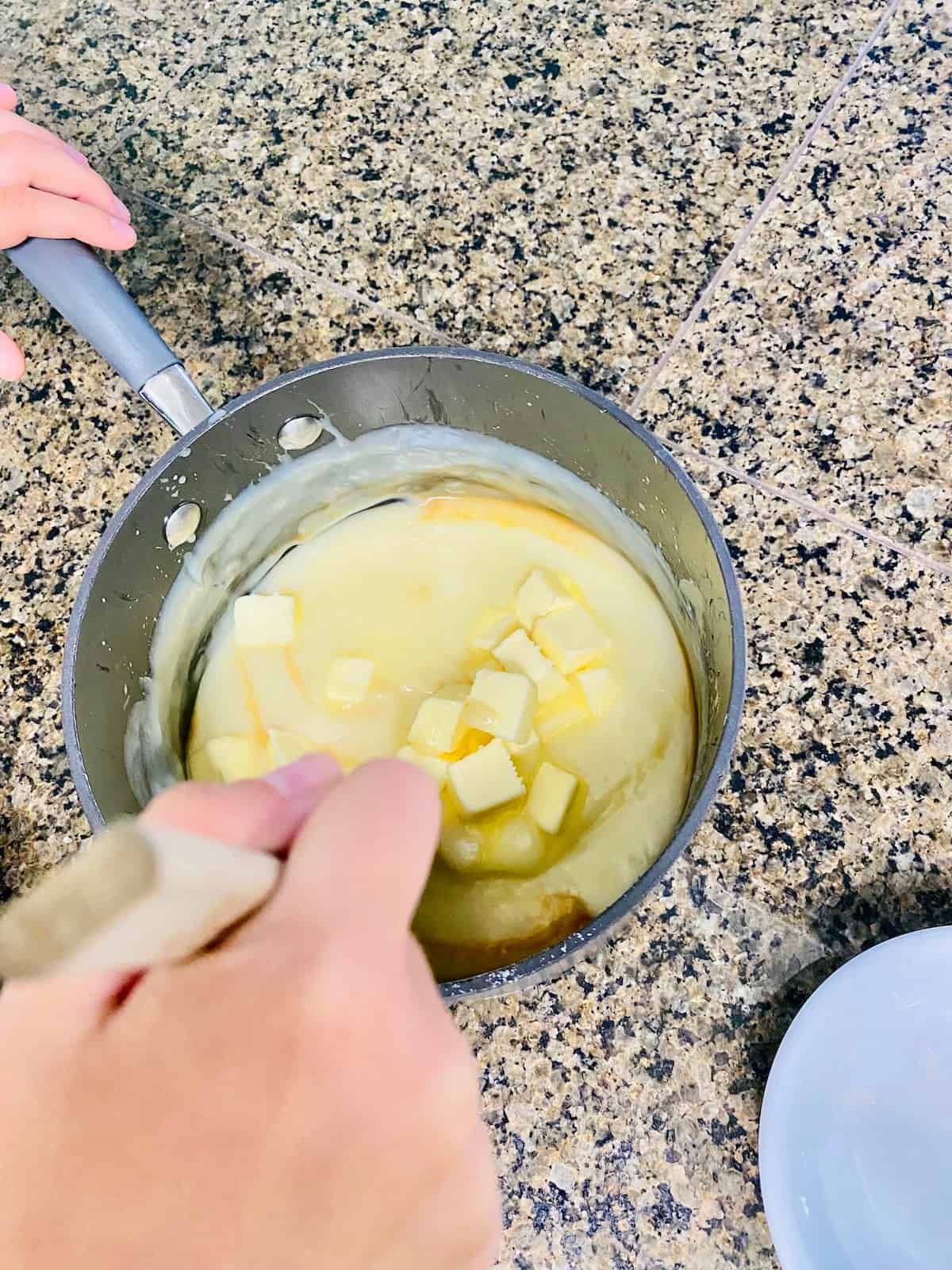 Adding butter and vanilla into the sugar cream custard.