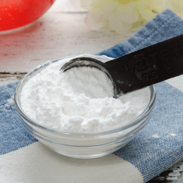A small bowl filled with baking powder substitute and spoon stirring it.
