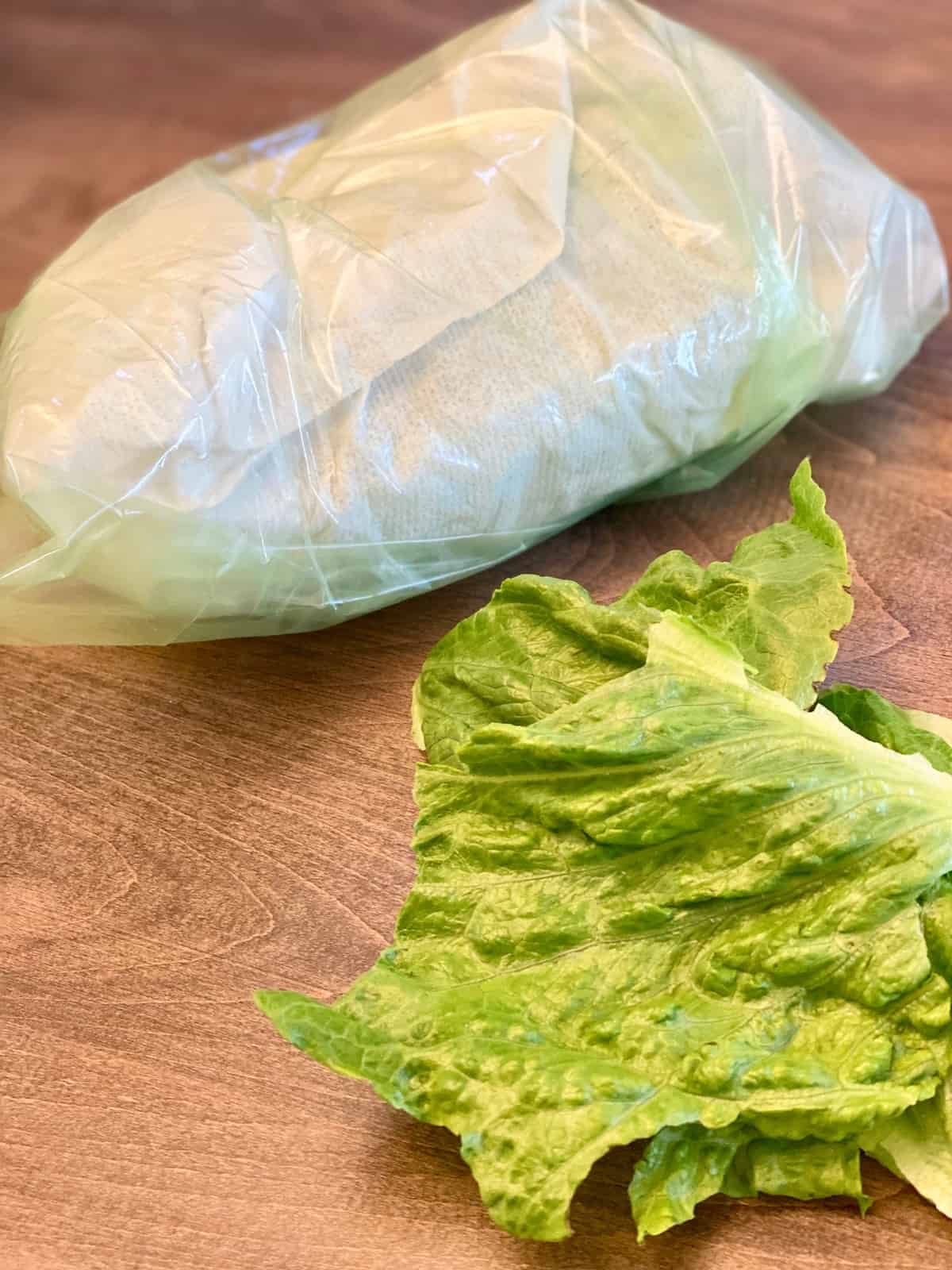 Fresh Wrapped lettuce in a green bag ready to store in the fridge.