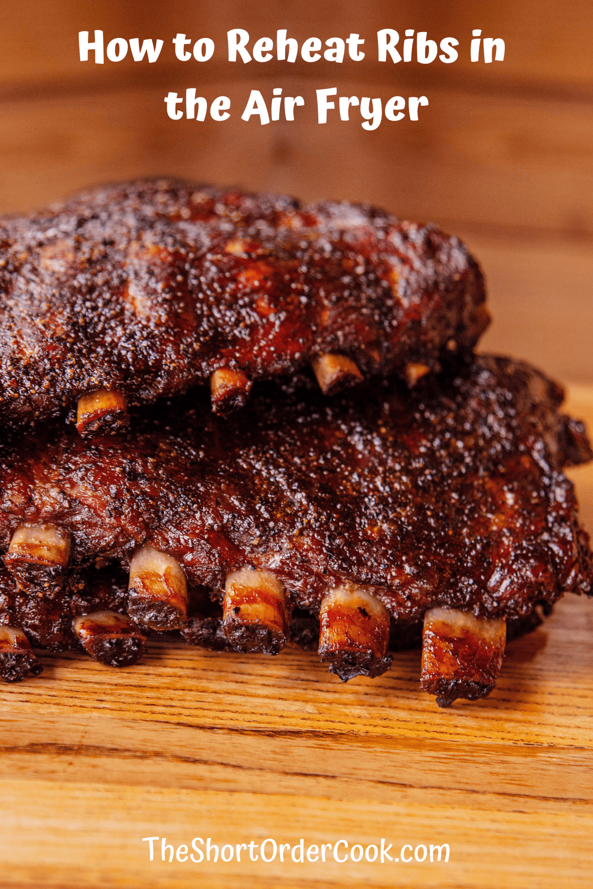 A cutting board with two racks of cooked ribs on it.