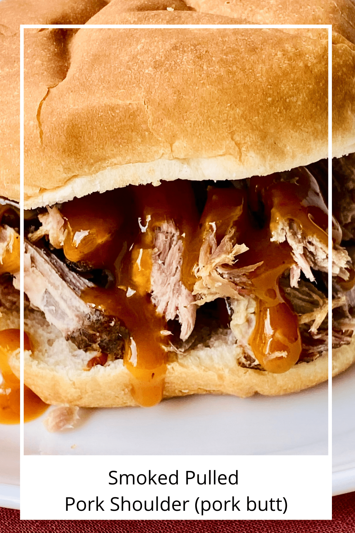 Closeup of a bun topped with tender smoked pulled pork and Caroline bbq sauce. 