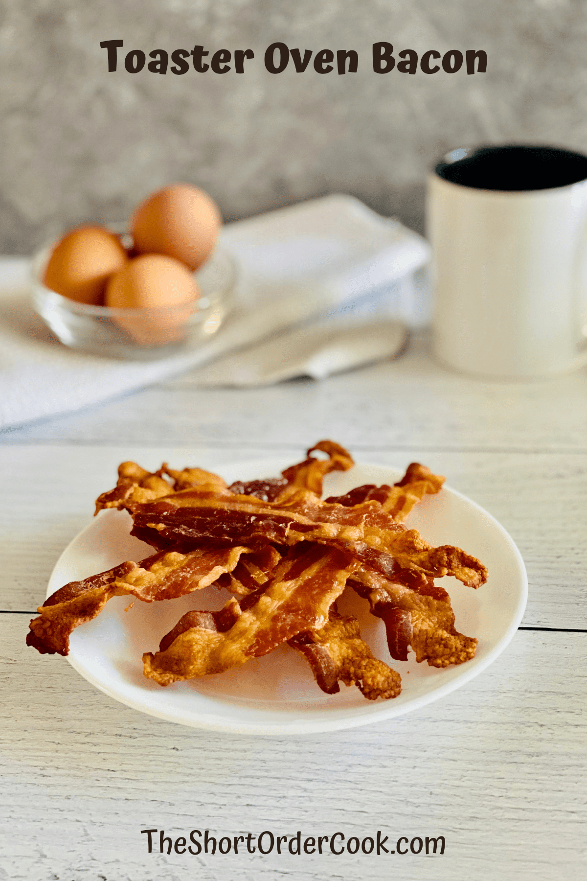 Plated bacon with eggs and coffee mug on the counter.