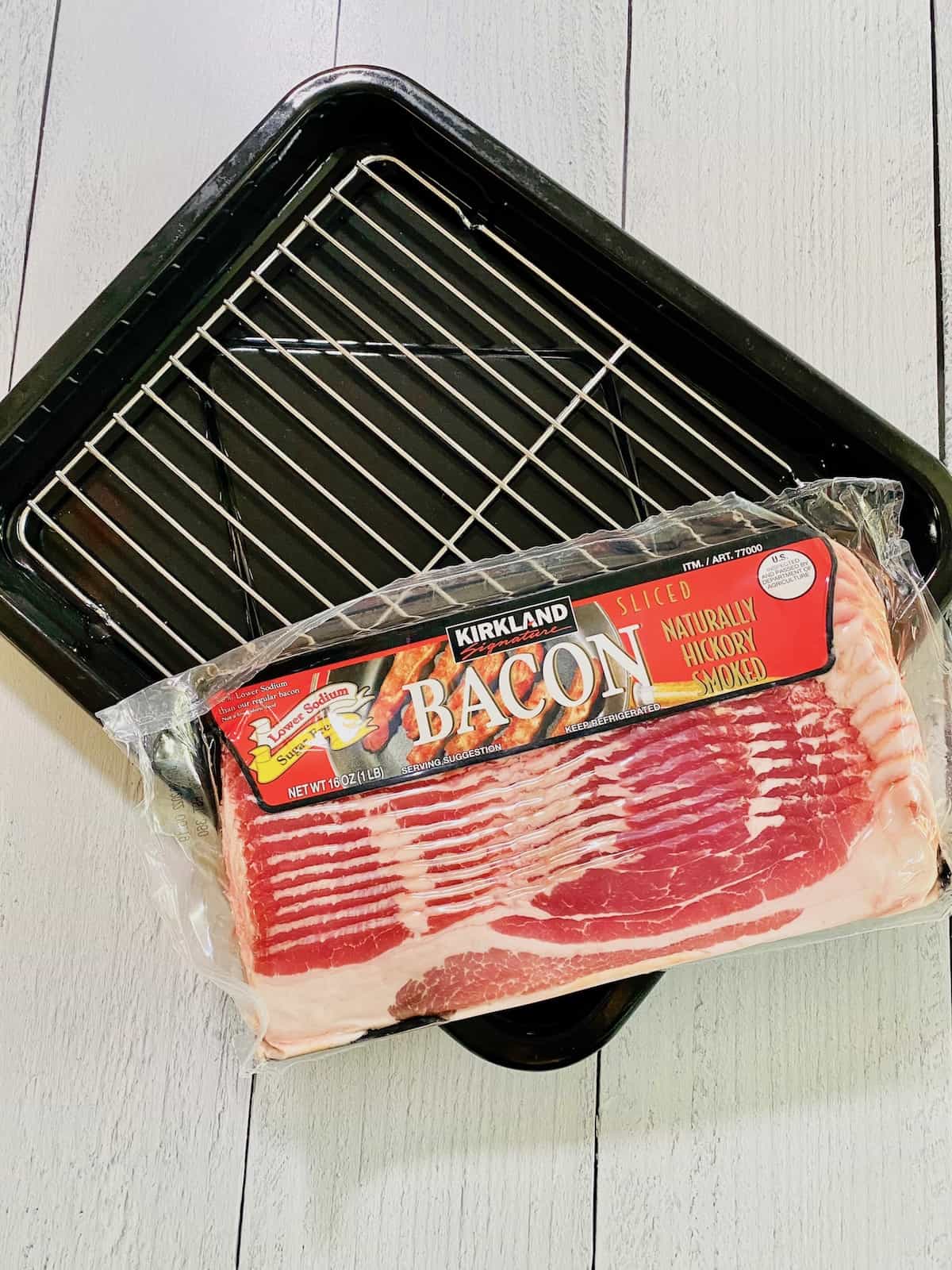 Packet of bacon and a toaster oven pan with a rack.