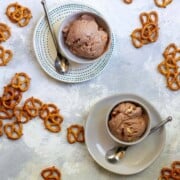 Two bowls with scoops of stout beer chocolate ice cream with pretzels.