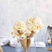 Two cones with a scoop of gooey butter cake ice cream.