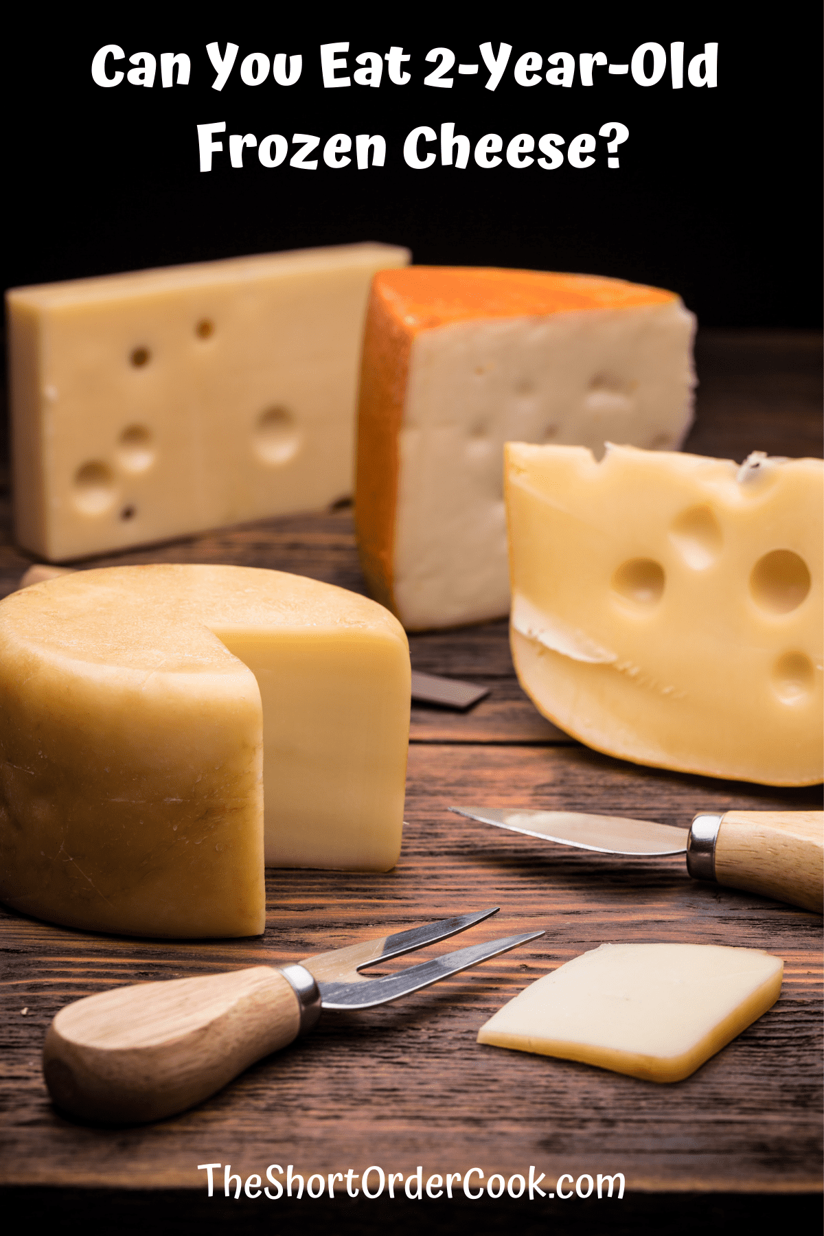 Several blocks of cheese on a cutting board with cheese knives.