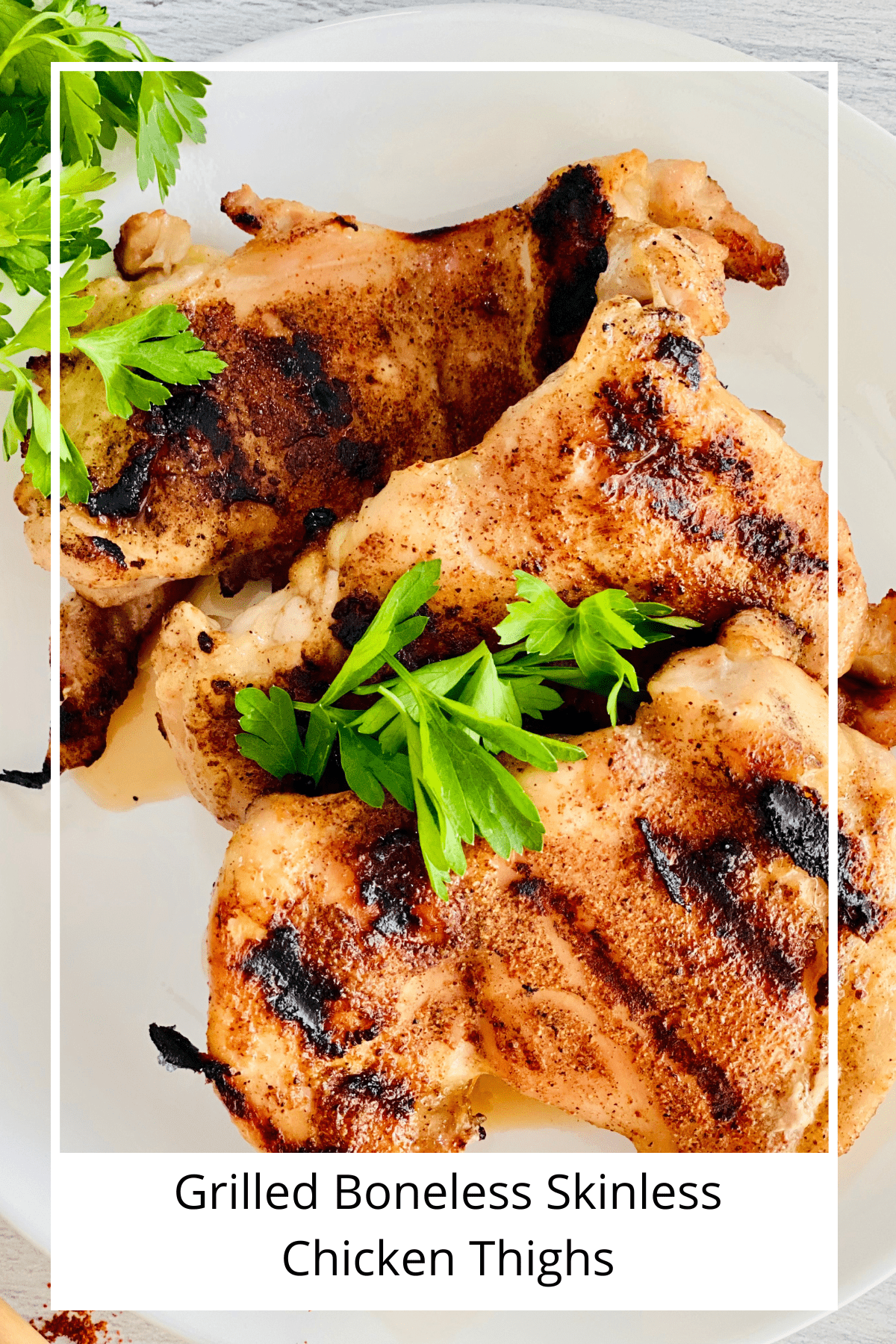Closeup of chicken thighs with a sugar and spice blend cooked on the grill with grill marks and topped with parsley.