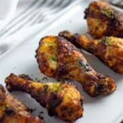 Plated charred chicken drumsticks from the air fryer.