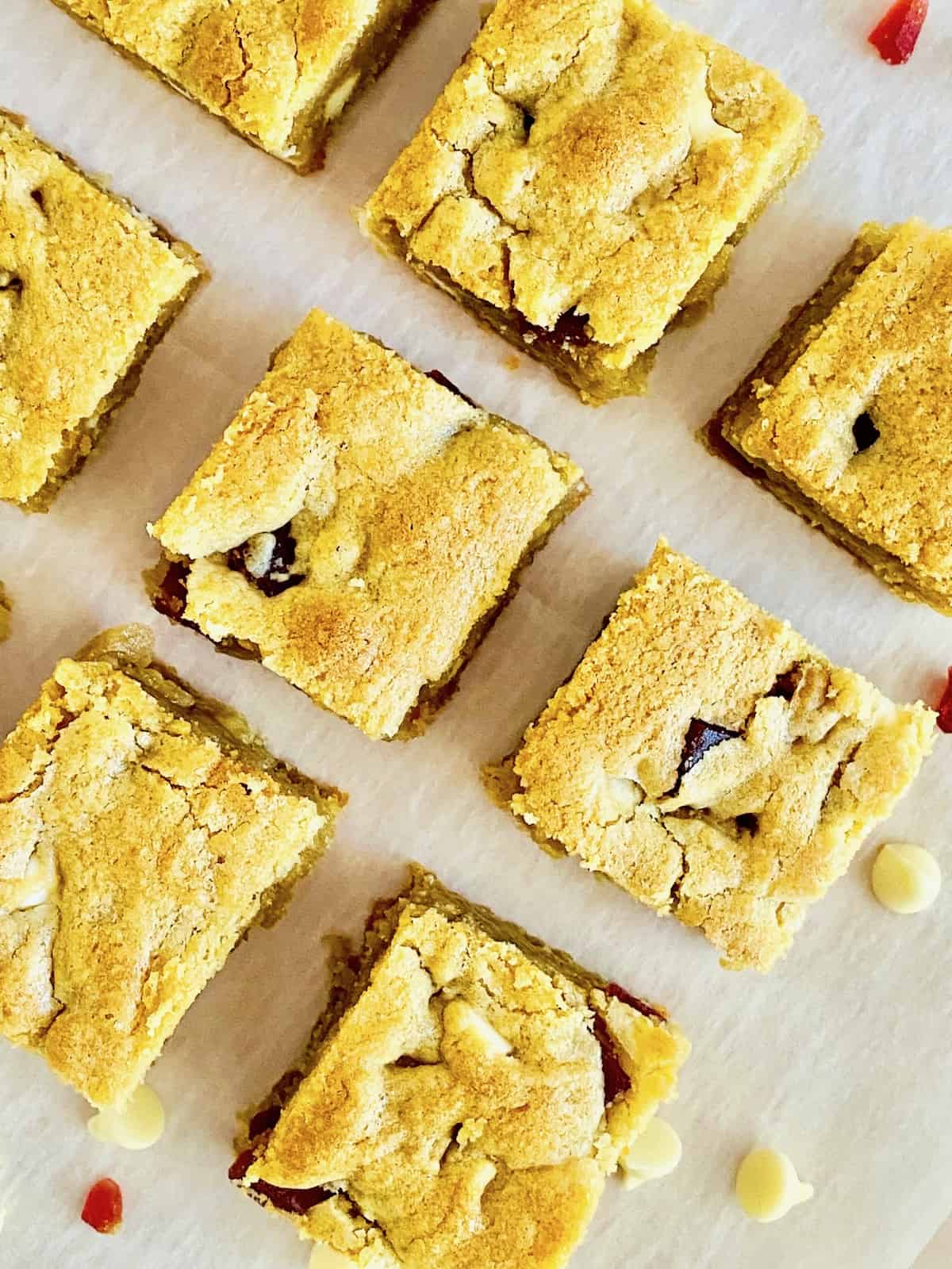 Strawberries & Cream Cookie Bars cut into squares on parchment overhead.