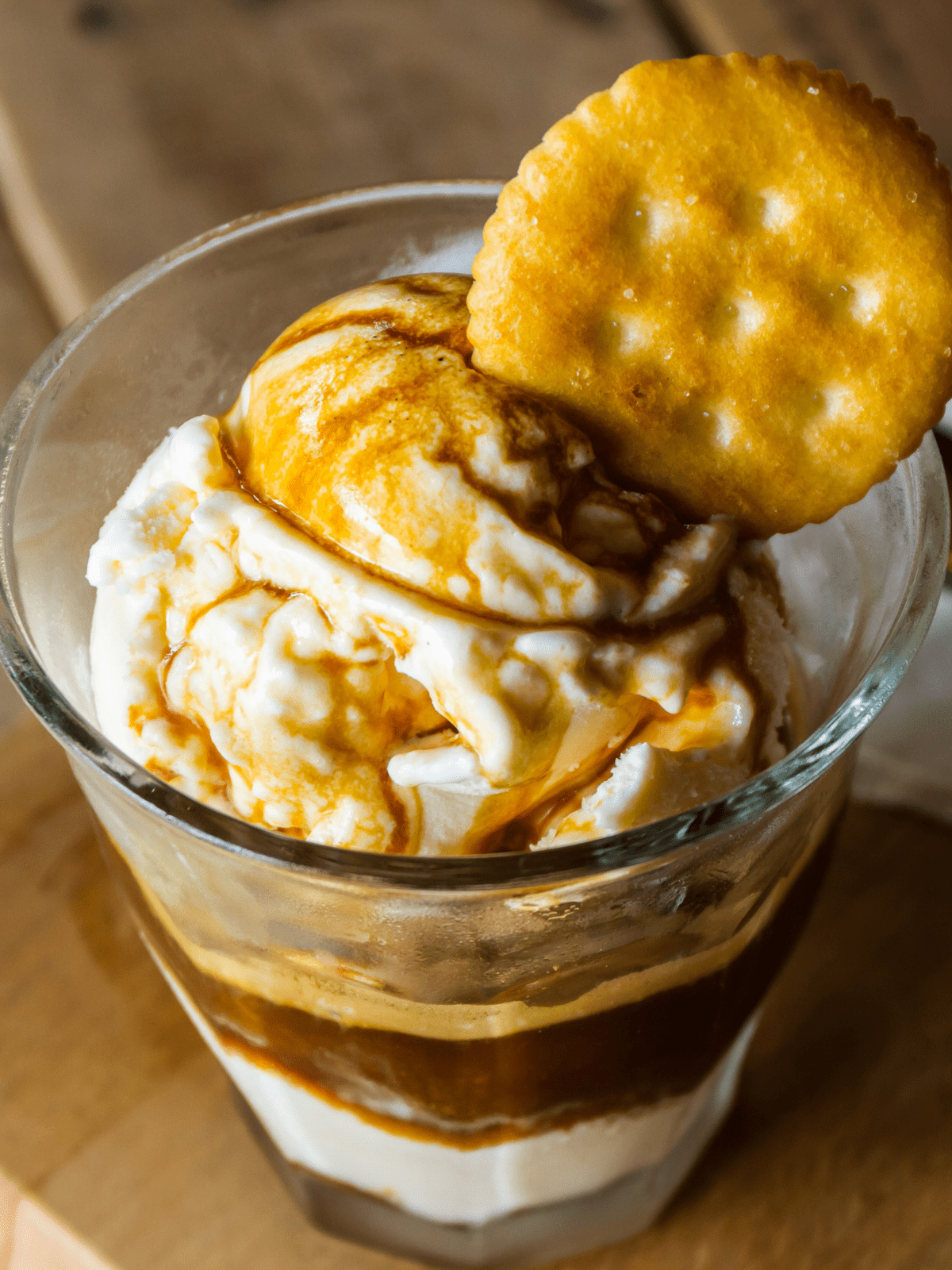 Vanilla ice cream in a glass topped with espresso and a Ritz cracker.